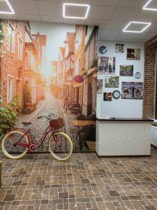 a bike parked in front of a painting of a street at Hotel Rover in Lviv