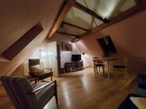 an attic living room with a table and chairs at Ferienwohnung im idyllischen Jena Ziegenhain in Jena