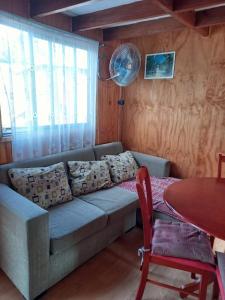 a living room with a couch and a table at Cabañas Cadiz Valdivia in Valdivia