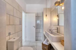 a white bathroom with a sink and a toilet at The view 1 in Kampos Paros