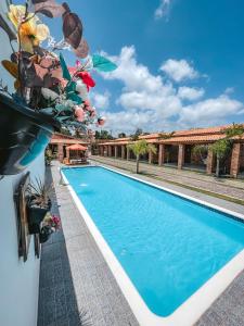 a swimming pool with a vase of flowers next to a building at Pousada Vasto Horizonte in Barreirinhas