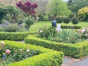 um jardim com uma variedade de flores e arbustos em Amuri Villas em Clive