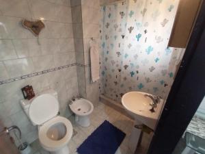 uma casa de banho com um WC, um bidé e um lavatório. em Alojamiento Entero con Excelente Ubicación em Morón