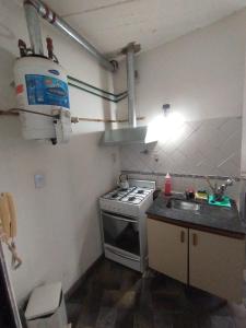 uma pequena cozinha com um fogão e um lavatório em Alojamiento Entero con Excelente Ubicación em Morón
