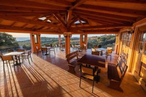 a screened porch with tables and chairs and windows at Gordia organic winery in Hrvatini
