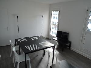 - un salon avec une table noire et un piano dans l'établissement Résidence Kerhallet, à Brest