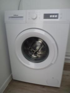 uma máquina de lavar roupa branca sentada num quarto em Résidence Kerhallet em Brest