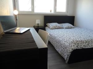 a bedroom with a bed and a laptop on a desk at Résidence Kerhallet in Brest