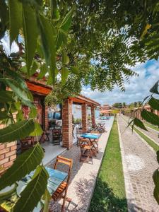 a house with a patio with tables and chairs at Pousada Vasto Horizonte in Barreirinhas
