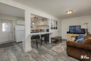 a living room with a couch and a kitchen at Chair Four Por Favor - Walk Almost Anywhere at Alyeska Resort! in Girdwood