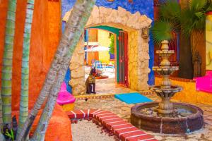 een fontein in het midden van een kamer met een gebouw bij Hacienda Maria Bonita Hotel in Playa del Carmen