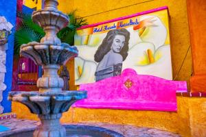 a mural of a woman on a wall with a fountain at Hacienda Maria Bonita Hotel in Playa del Carmen