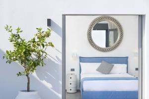 a bedroom with a blue bed and a mirror at Elounda Villa Kalydon in Elounda