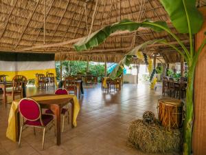 a restaurant with tables and chairs and a large umbrella at Drift Inn Cayo in Santa Elena