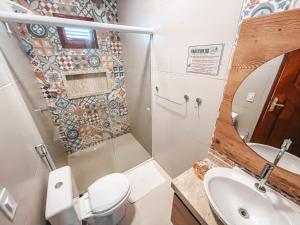 a bathroom with a toilet and a sink and a mirror at Pousada Vasto Horizonte in Barreirinhas