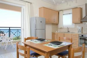 a kitchen with a table with chairs and a refrigerator at Thea Studios in Finikounta