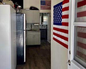 a kitchen with an american flag on the door at Biker's Bungalow - Near Mendenhall Glacier and Auke Bay Offering DISCOUNT ON TOURS! in Mendenhaven
