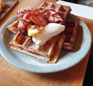 a plate of waffles with an egg and butter at Broadway Motor Inn in Palmerston North