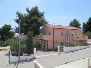 una casa rosa al lado de una calle en Apartments Luvi, en Trogir