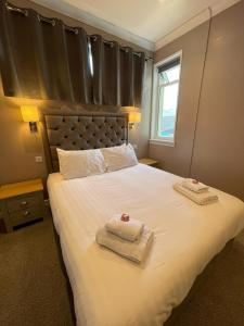 カイル・オブ・ロカルシュにあるThe Skye Bridge Hotelのベッドルーム1室(大型ベッド1台、タオル付)