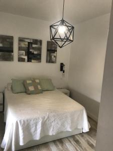 a bedroom with a white bed and a black light at Casa Norah Pc in Puerto del Carmen