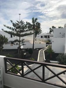einen Balkon mit Blick auf eine Straße und Palmen in der Unterkunft Casa Norah Pc in Puerto del Carmen