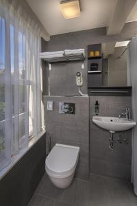bagno con servizi igienici bianchi e lavandino di Stanley Collection Hotel Hegra Amsterdam ad Amsterdam