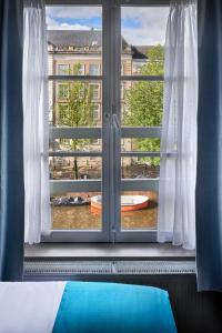 a window with a view of a building at Stanley Collection Hotel Hegra Amsterdam in Amsterdam