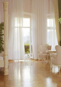 a living room with a chair and a window at Pałac Brunów - Wellness & SPA in Lwówek Śląski