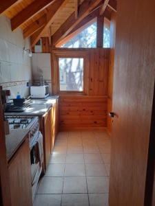 cocina con fogones y ventana en Departamentos Sonne Depto Planta Alta en San Martín de los Andes