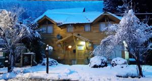 una cabaña de madera en la nieve con árboles nevados en Departamentos Sonne Depto Planta Alta en San Martín de los Andes