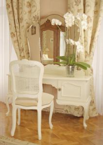 a white desk with a vase of flowers and a mirror at Pałac Brunów - Wellness & SPA in Lwówek Śląski