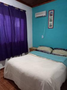 um quarto com uma cama com uma parede azul em Casa con Gran Patio em Villa Parque Síquiman