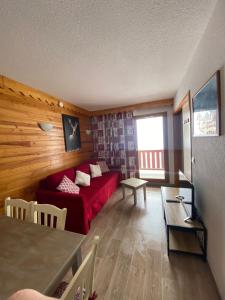 a living room with a red couch and a table at Appartement lumineux aux pieds des pistes in Saint-François-Longchamp