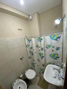 y baño con aseo y cortina de ducha. en Costa Selva en Posadas