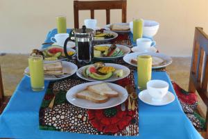 einen Tisch mit Teller mit Lebensmitteln auf einem blauen Tischtuch in der Unterkunft Mafia Neptune Villa Lodge in Utende