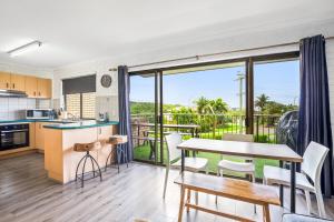 a kitchen and dining room with a view of the ocean at WINDARRA-Alex Headland Family Holiday in Alexandra Headland