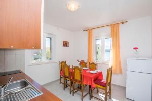 a kitchen with a table with a red table cloth at Apartment Island Sun Terrace in Krapanj