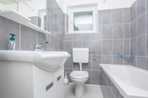 a bathroom with a toilet and a sink and a tub at Apartment Island Sun Terrace in Krapanj +26 photos