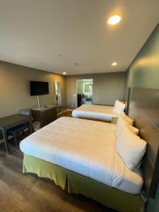 Habitación de hotel con 2 camas y TV en Hotel Milagro, en Chula Vista