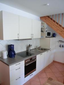 una cocina con armarios blancos y fregadero en Ferienwohnung N18, en Graal-Müritz
