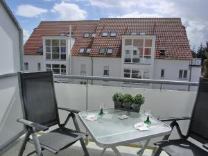- Balcón con mesa y 2 sillas en edificios en Ferienwohnung N18, en Graal-Müritz