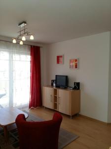 un soggiorno con un tavolo e una televisione di Ferienwohnung H 11 a Graal-Müritz