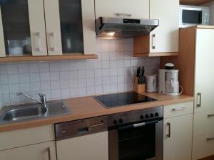 uma cozinha com um lavatório e um fogão forno superior em Ferienwohnung H 11 em Graal-Müritz