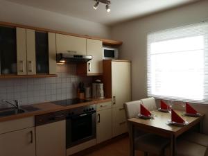 una cucina con tavolo con due libri rossi sopra di Ferienwohnung H 11 a Graal-Müritz 1 altra foto