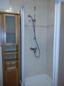 um chuveiro com uma porta de vidro na casa de banho em Ferienwohnung H 11 em Graal-Müritz