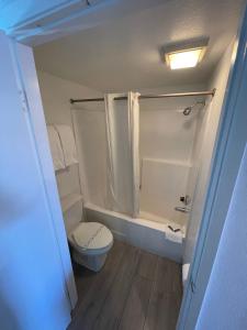 a small bathroom with a toilet and a shower at Hotel Milagro in Chula Vista