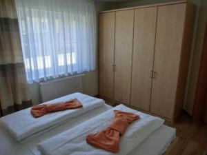 een slaapkamer met 2 bedden en bruine badjassen bij Ferienwohnung Ahoi LFR14 in Graal-Müritz