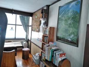 a room with a book shelf filled with books at Ekinoyado Hirafu in Kutchan