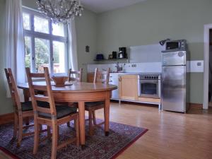 a kitchen with a table and chairs and a refrigerator at Strandstraße 60 Ferienwohnung S12 in Graal-Müritz +3 photos
